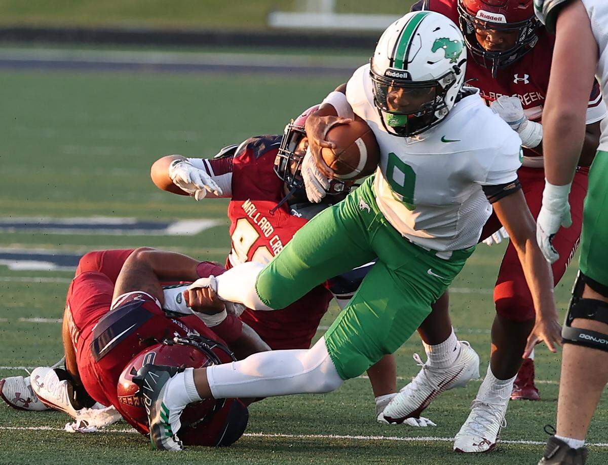 Myers Park Mustangs quarterback Ramir Watson fights to escape the Mallard Creek Mavericks defense during action on Friday, September 12, 2025 at Mallard Creek High School.