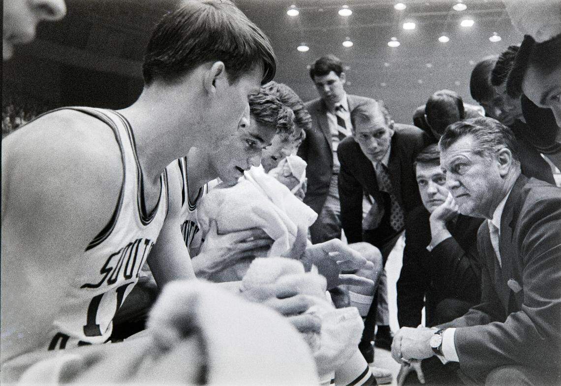 South Carolina basketball coach Frank McGuire gives instructions to his players during a game in the 1969 ACC Tournament in Charlotte, NC. John Roche is at left.
