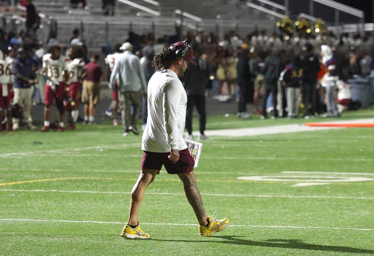 West Charlotte head football coach Sam Griner walks back to the team’s sideline after checking on a player’s loved one who had to be tended to by medic following a chaotic scene that erupted near the 9:19 mark of third quarter action of the West Charlotte vs Mallard Creek football game. The disruption had players and fans scrambling for safety on Friday, September 20, 2024 at West Charlotte High in Charlotte, NC.
