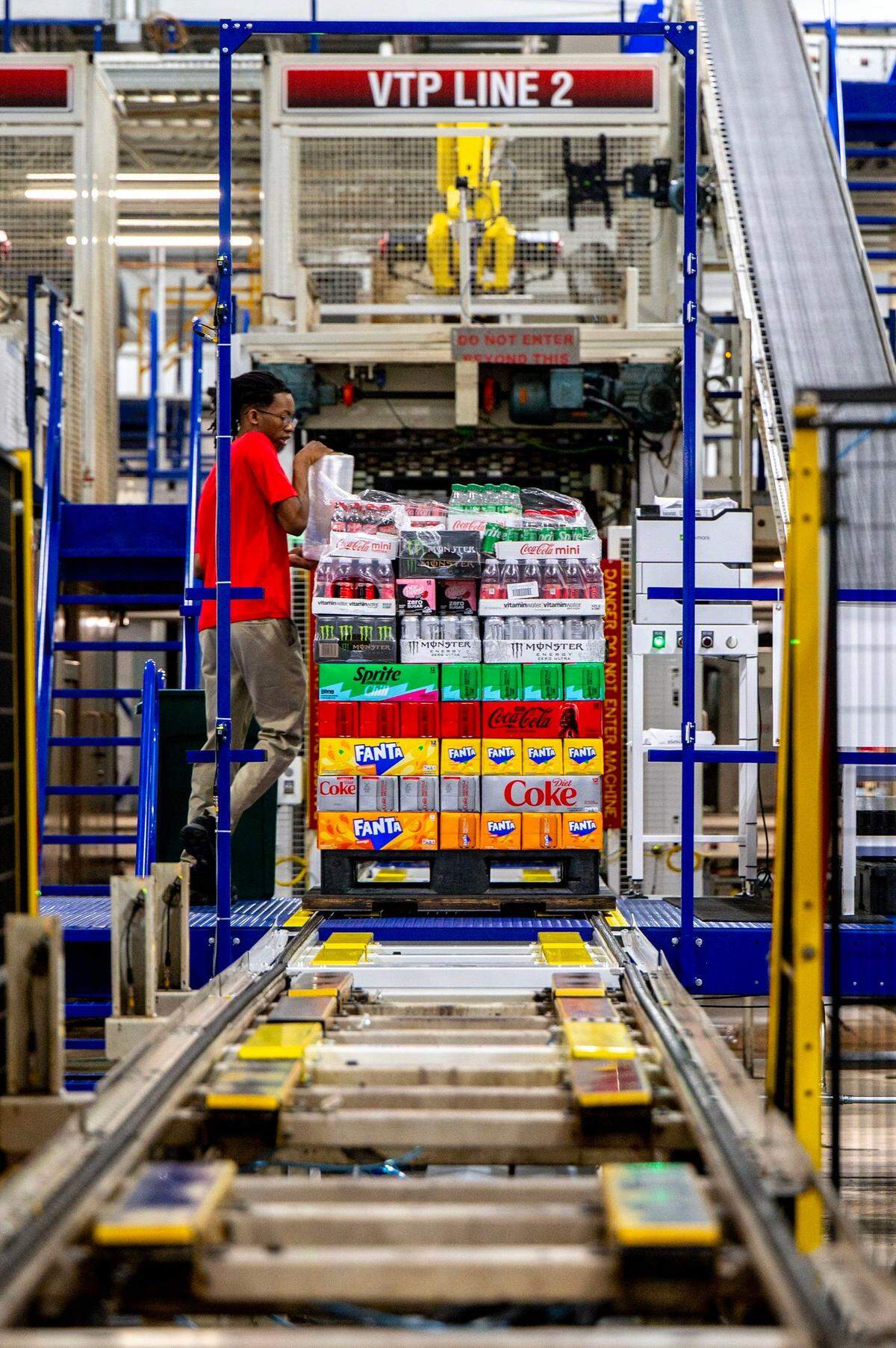 A Coca-Cola team member wraps a pallet stacked with Coca-Cola merchandise while NC Gov. Josh Stein tours the Consolidated facility in Charlotte, NC, Wednesday July 23, 2025.