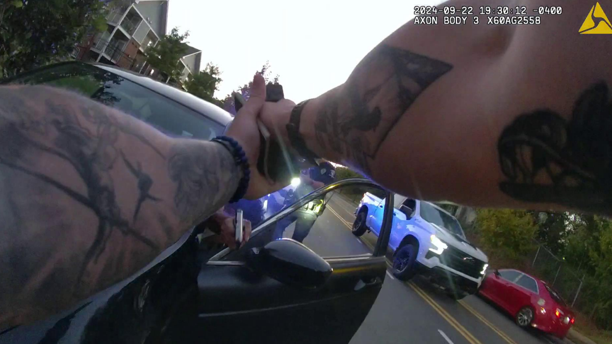 An image from police body-camera video shows Nerin Funez-Reyes pointing a gun from inside the car at Charlotte-Mecklenburg Police Department Officer Joshua Heater.