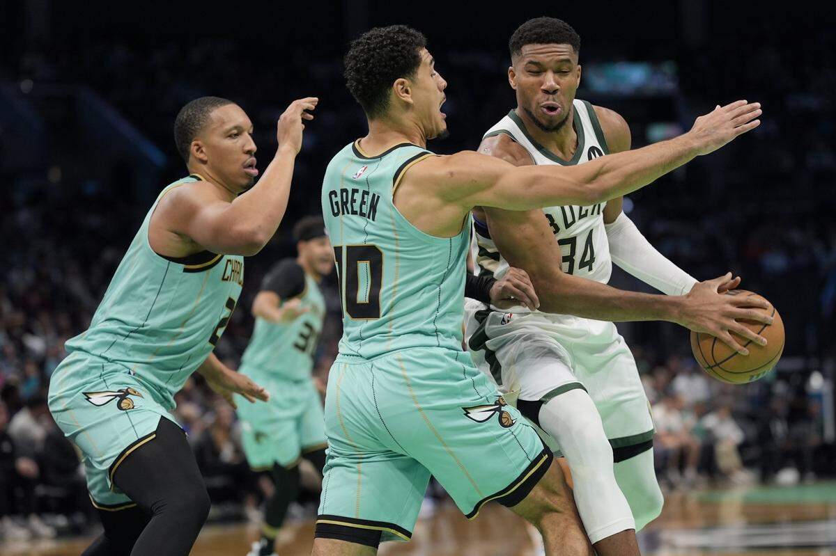 Milwaukee Bucks forward Giannis Antetokounmpo (34) is pressured by Charlotte Hornets guard Josh Green (10) and forward Grant Williams (2) during the second quarter at Spectrum Center. 
