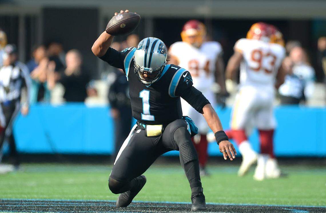 Carolina Panthers quarterback Cam Newton places the ball at midfield following his rushing touchdown and before his Superman celebration against Washington Sunday.