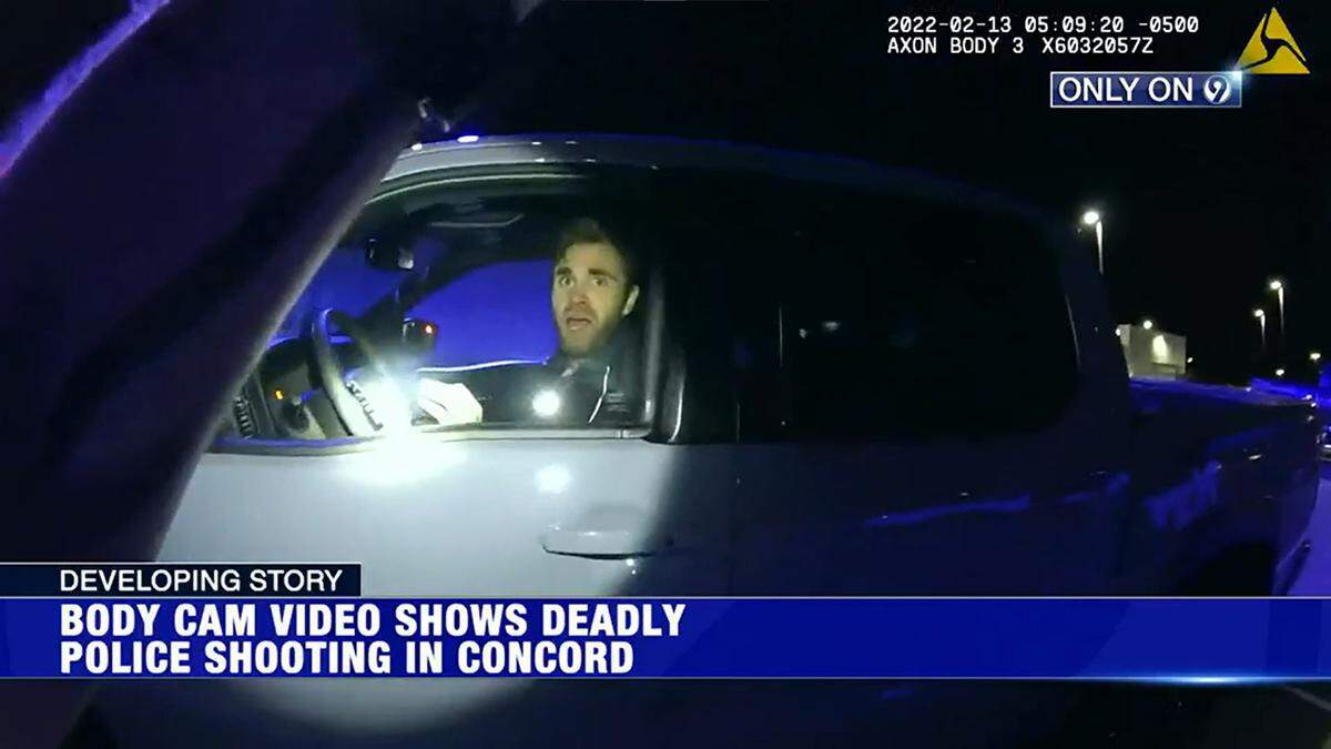 In this image from video provided to WSOC, Brandon Combs looks at now-former Officer Timothy Larson from inside a pickup truck at a Nissan dealership in Concord, N.C., on Feb. 13, 2022. Moments later, Combs fled the pickup and jumped into Larson’s police SUV.