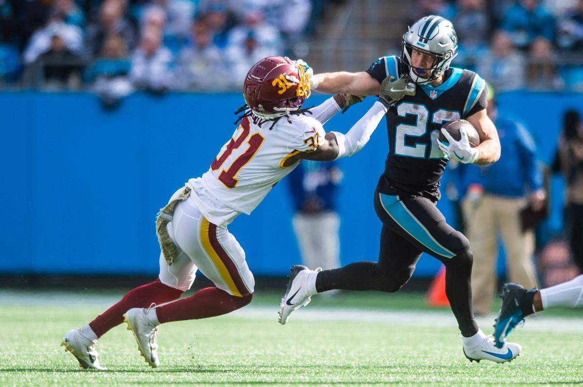 Panthers running back Christian McCaffrey stiff arms the Washington Football Teams free safety Kamren Curl during the game at Bank of America Stadium on Sunday, November 21, 2021 in Charlotte, NC.