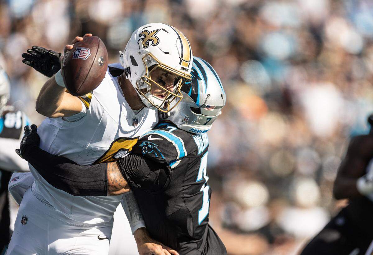 New Orleans Saints quarterback Tyler Shough, left, is sacked by Carolina Panthers safety Tre'von Moehrig at Bank of America Stadium in Charlotte, North Carolina, on Nov. 9, 2025.