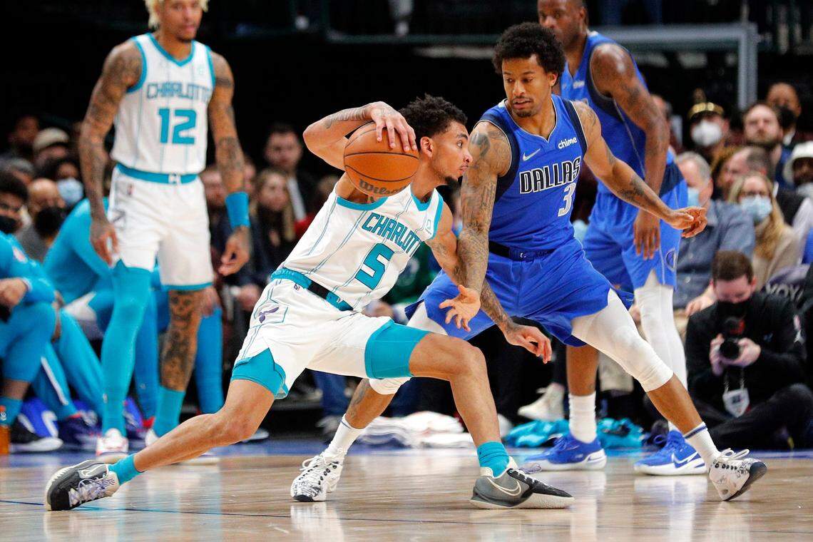 Charlotte Hornets guard James Bouknight (5) tries to drive past Dallas Mavericks guard Trey Burke (3) in the first half of an NBA basketball game Monday, Dec. 13, 2021, in Dallas. (AP Photo/Richard W. Rodriguez)