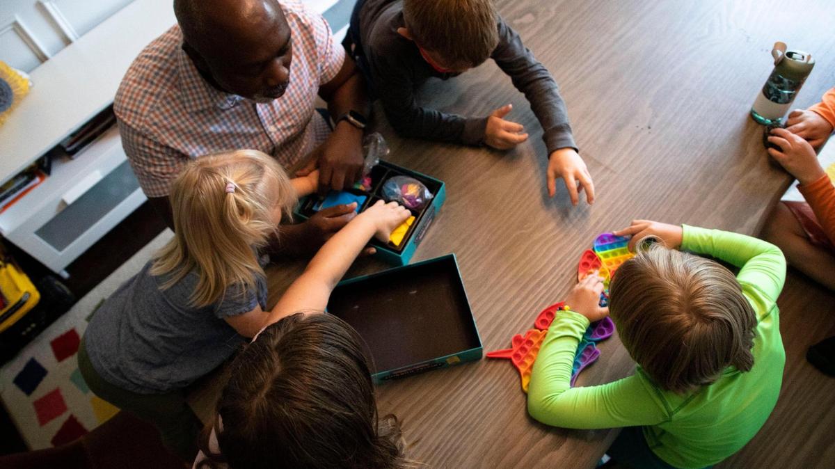 Peter Mutabazi plays a game with all five of his foster children on Wednesday, June 5, 2023 at his Charlotte home. Mutabazi has had 34 foster kids since his begging in the foster system.