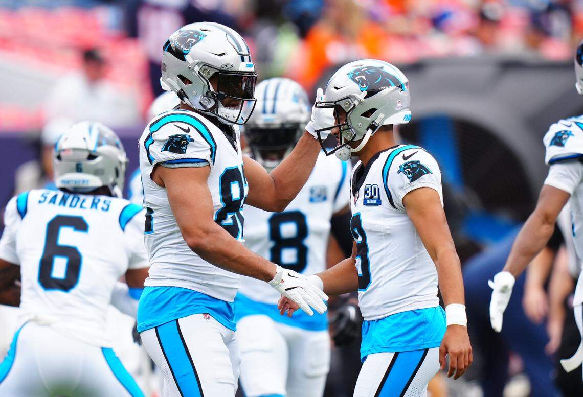 Carolina Panthers quarterback Bryce Young (right) greets tight end Tommy Tremble (82) before Sunday’s game against the Denver Broncos at Empower Field at Mile High. Ron Chenoy-Imagn Images