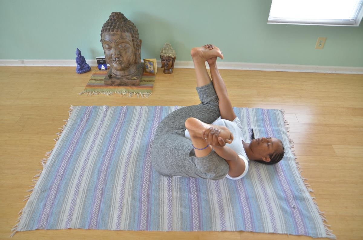 Yoga teacher Keisha Battles demonstrates happy baby yoga pose.