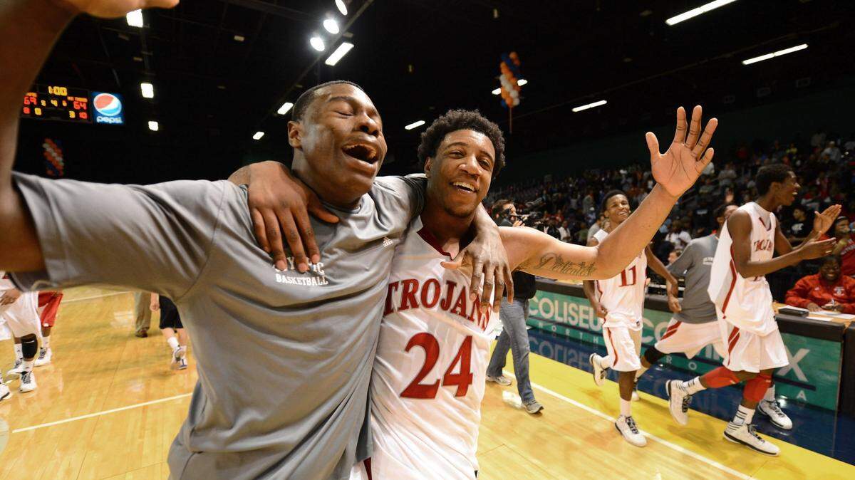 (Right) Olympic Trojans (24) BJ Gladden and a teammate celebrate their victory in the N.C. 4A Western Regional basketball championship on Saturday, March 9, 2013 at the Greensboro Coliseum Special Events Center in Greensboro, NC. Olympic defeated Mount Tabor 69-64 and will meet the N.C. 4A Eastern champion in Chapel Hill, NC on March 16, 2013. Jeff Siner - jsiner@charlotteobserver.com