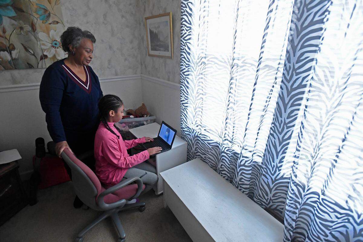 Regina Barrett stands with her granddaughter Hallie Barrett, 10, in the room she used as a remote classroom in ReginaÕs Monroe, NC home on Wednesday, February 10, 2021. Regina Barrett began juggling the roles of grandmother, caregiver and teacher when the pandemic shutdown schools last year..