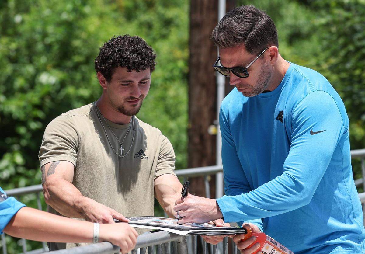 Panthers fan Tray Lee, left, smiles as he gets an autograph from President of Football Operations/General Manager, Dan Morgan during the second day of minicamp in Charlotte, NC on Wednesday, June 11, 2025.