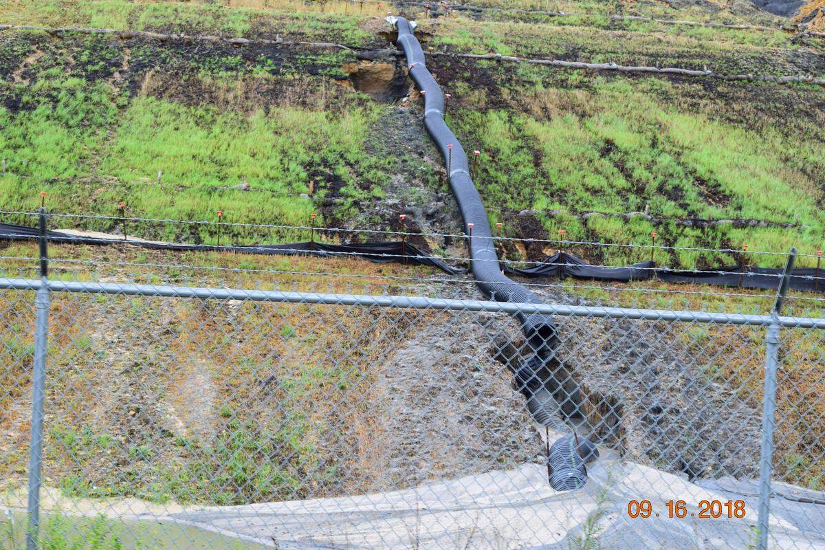 Gray water containing coal ash flows from a ruptured landfill at Duke Energy’s Sutton station in Wilmington toward Sutton Lake in this file photo from 2018.