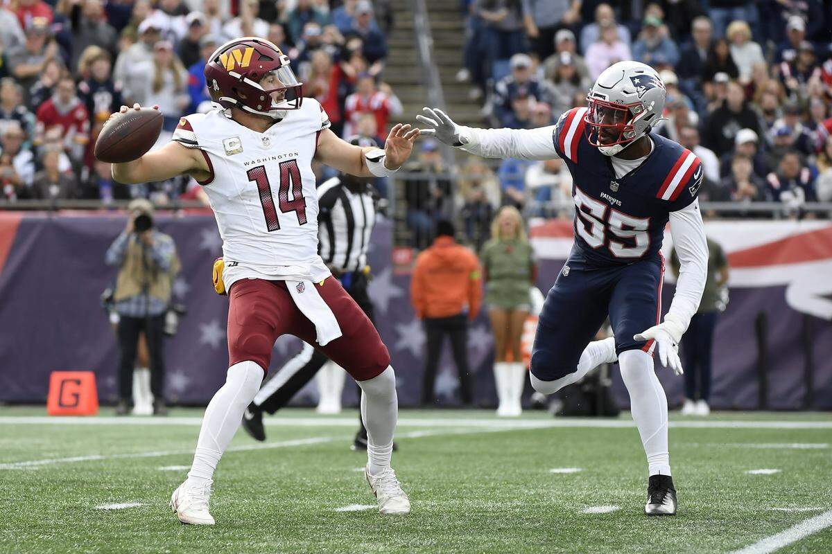 Nov 5, 2023; Foxborough, Massachusetts, USA; Washington Commanders quarterback Sam Howell (14) gets set to throw a pass while New England Patriots linebacker Josh Uche (55) defends during the first half at Gillette Stadium. Mandatory Credit: Bob DeChiara-USA TODAY Sports