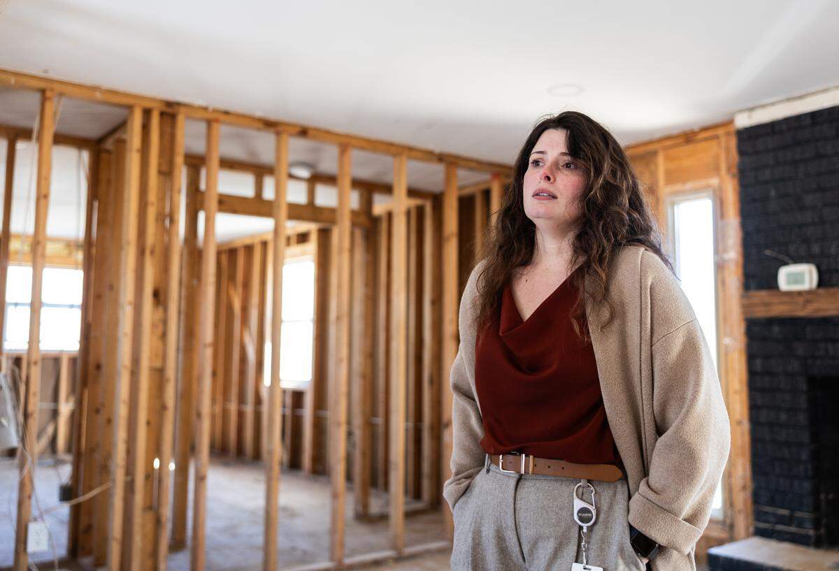 Taylor Atwood, photographed standing in her flood-damaged Riverside Drive home in January. Five months later, she and her partner Eddie are still far from being able to move back in.