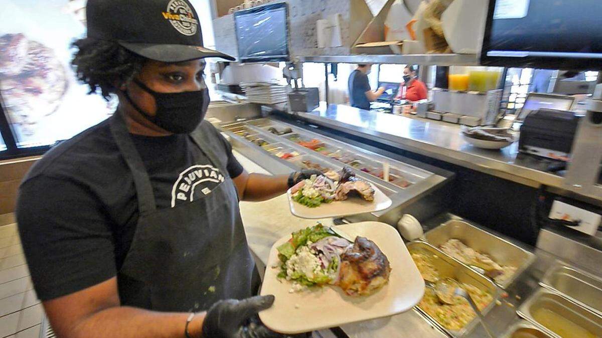 Amber Irby fills an order at Viva Chicken Waverly on May 14. The fast-casual Peruvian rotisserie chain has added a hiring bonus to to appeal to more applicants amid a nationwide worker shortage.