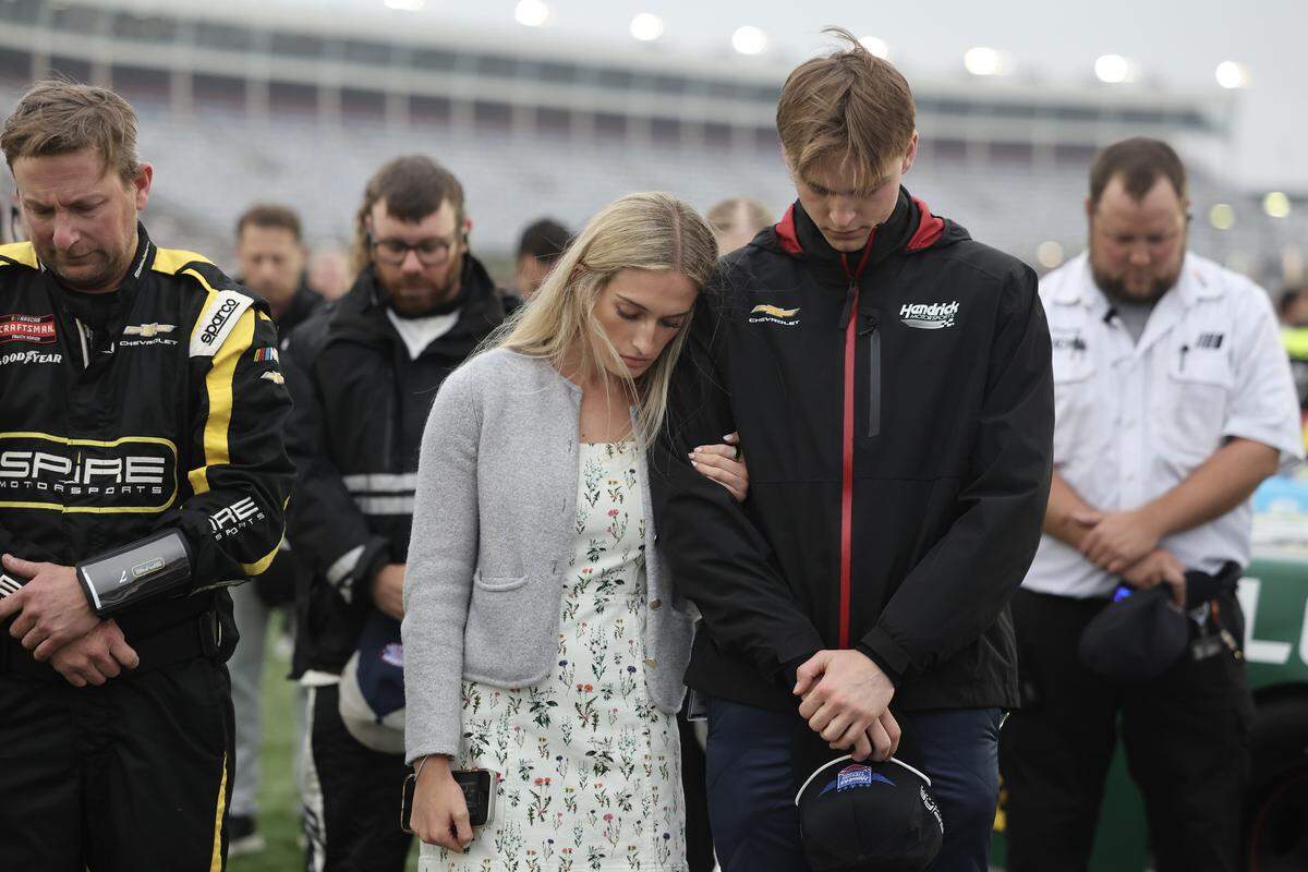 Corey Day, right, and girlfriend Ashlyn Rodriguez pray before Day drives Kyle Busch's car Friday, May 22, 2026 at Charlotte Motor Speedway.