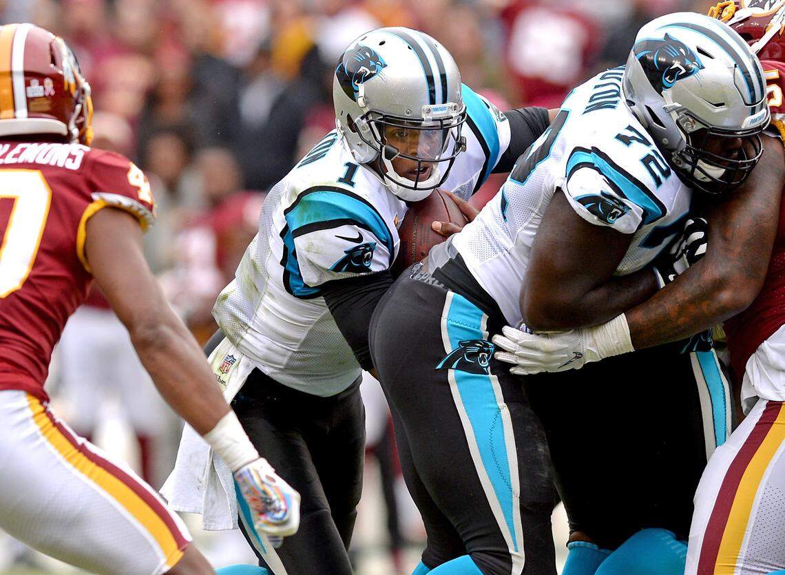 Carolina Panthers quarterback Cam Newton, center, follows his blocker tackle Taylor Moton, right, on a run up the middle during the team’s final series against Washington during late fourth quarter action at FedEx Field in Landover, Maryland on Sunday, October 14, 2018. Washington defeated the Panthers 23-17.