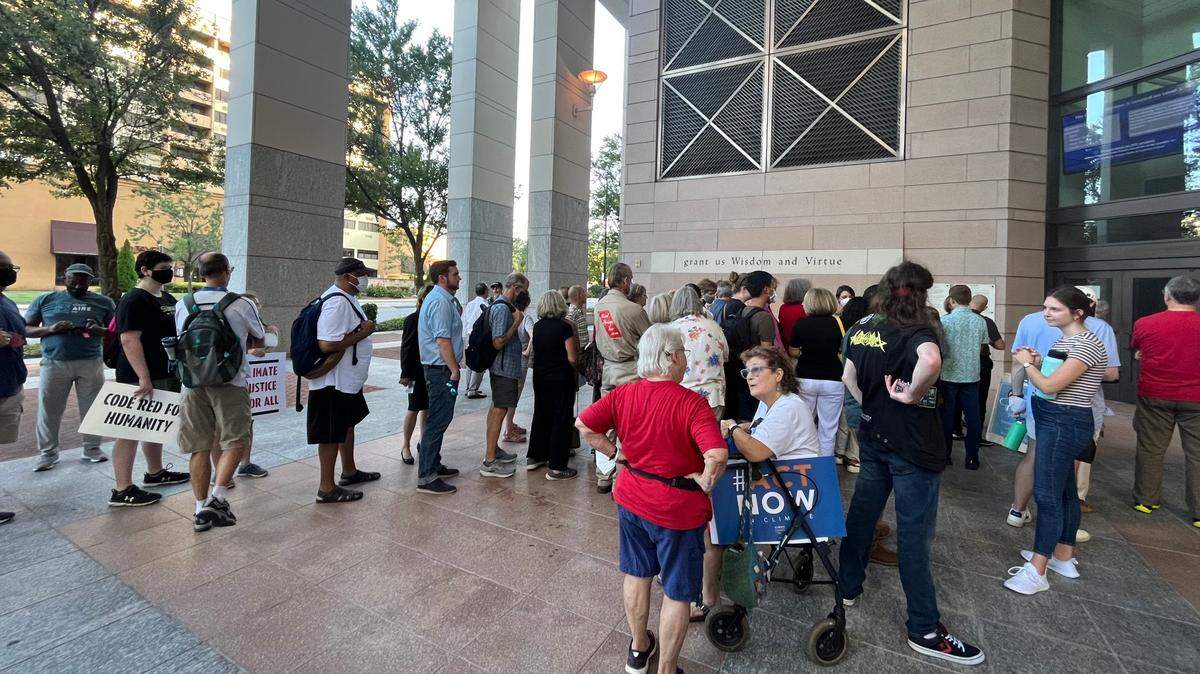 Environmental advocates wait to enter the Mecklenburg County Courthouse Thursday evening ahead of the carbon plan hearing.