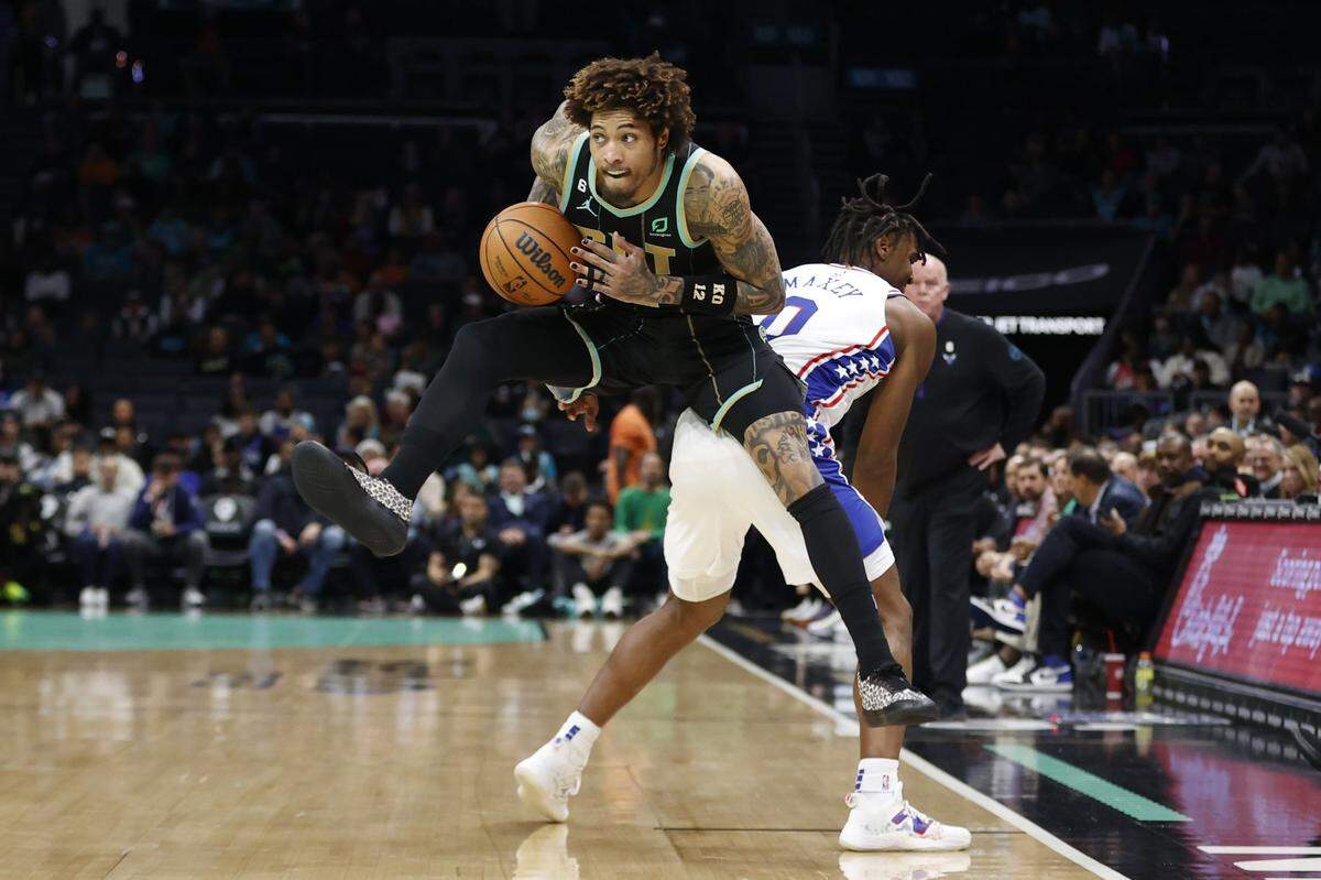Charlotte Hornets guard Kelly Oubre Jr. (12) keeps the ball away from Philadelphia 76ers guard Tyrese Maxey (0) during the first half at Spectrum Center.
