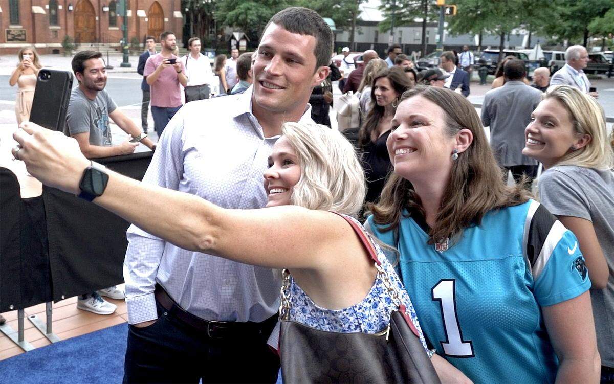 Carolina Panthers linebacker Luke Kuechly, left, poses for a photograph with fans along the blue carpet prior to the premiere of Amazon’s “All or Nothing” at the Knight Theater in Charlotte, NC on Thursday.