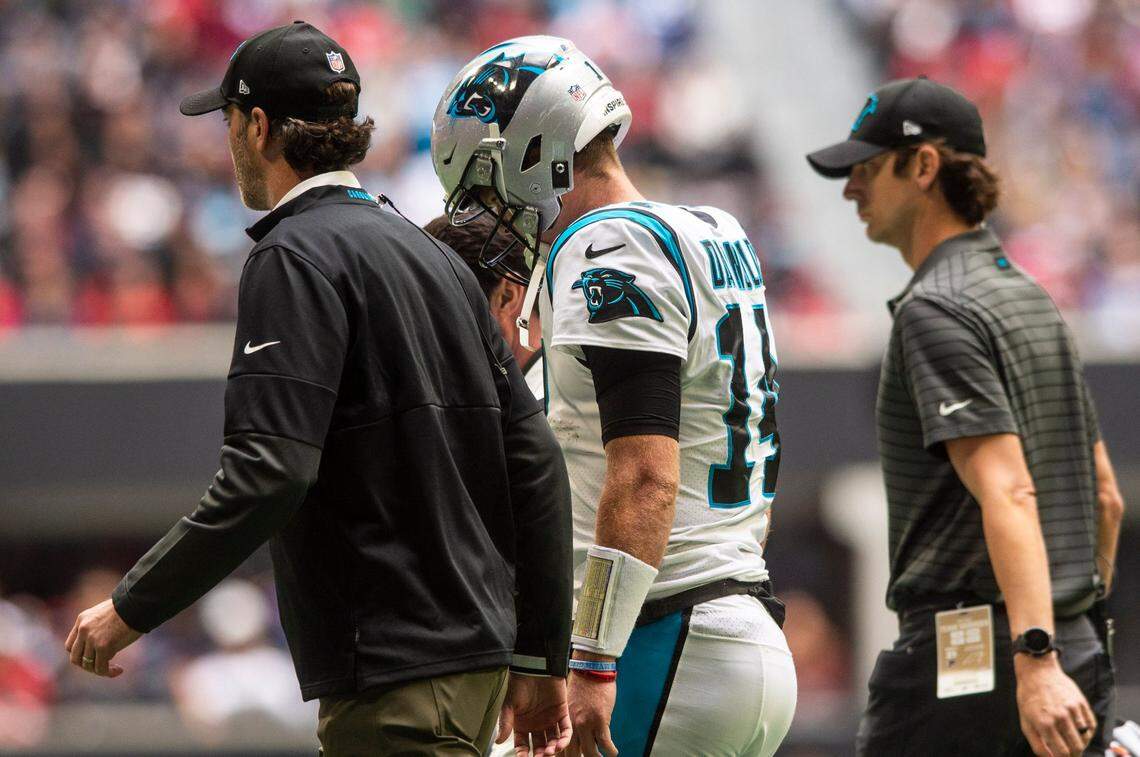 Panthers quarterback Sam Darnold, center, walks off the field with medical staff after colliding with Falcons Deion Jones during the game at Mercedes-Benz Stadium on Sunday, October 31, 2021 in Atlanta, GA.