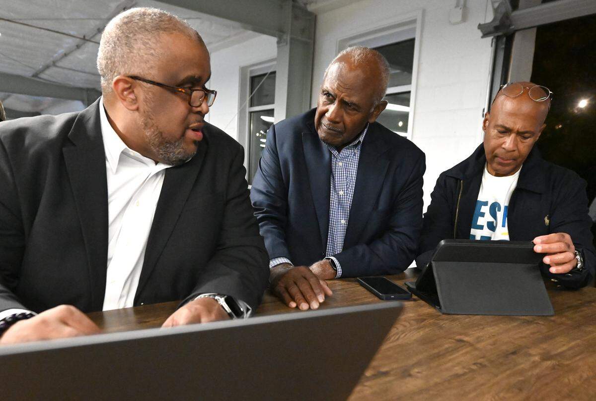 David Howard, left, former Charlotte mayor Harvey Gantt, center and Kevin Monroe, right, look over results in the one percent transportation referendum following polls closing on Tuesday, November 4, 2025.