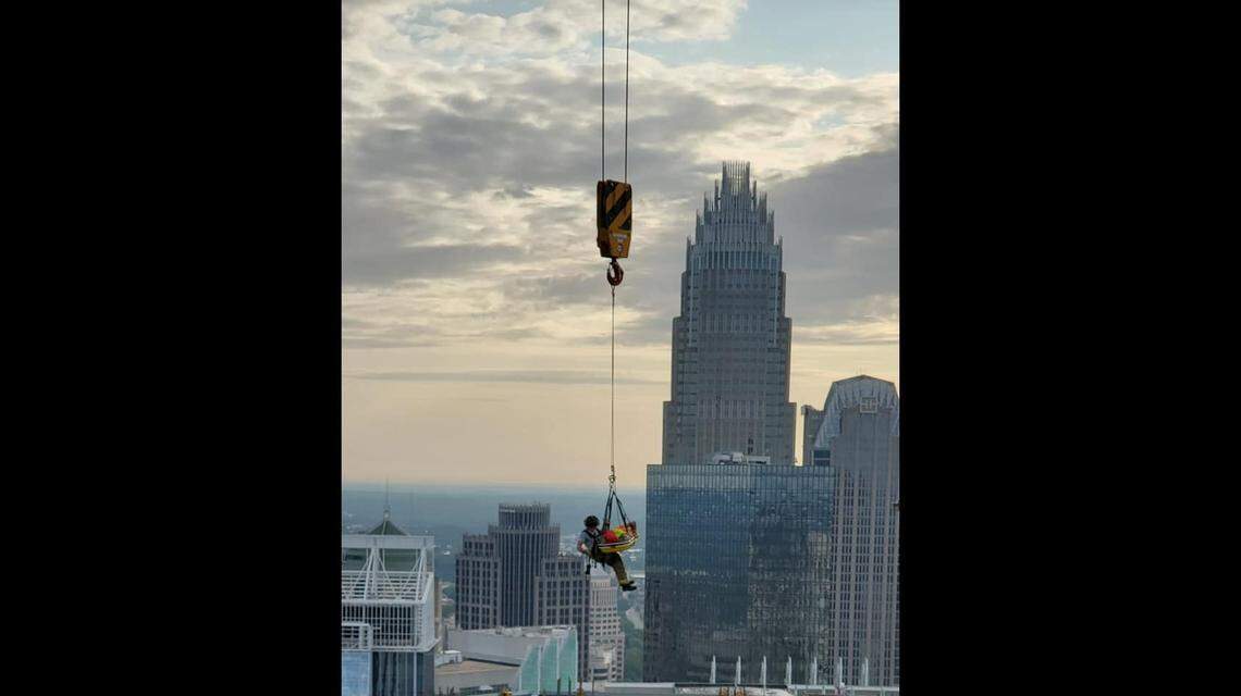 The Charlotte Fire Department released photos of a “high angle rescue” that saw a firefighter dangling from a cable 40 stories over uptown.