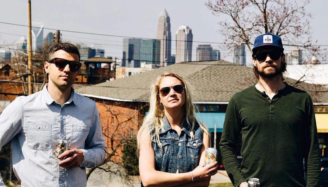 Burial Beer Co. owners Doug Reiser, Jess Reiser and Tim Gormley pose from the roof of 1214 Thomas Ave. in 2021.
