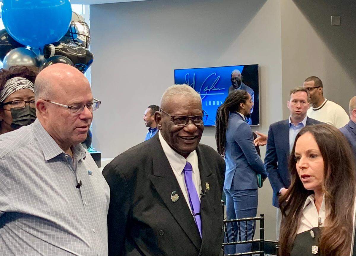 From left: Panthers owner David Tepper, longtime team employee John Coleman and Nicole Tepper, David’s wife, talk as they look at the plaque that will honor Coleman in the lobby of Bank of America Stadium.