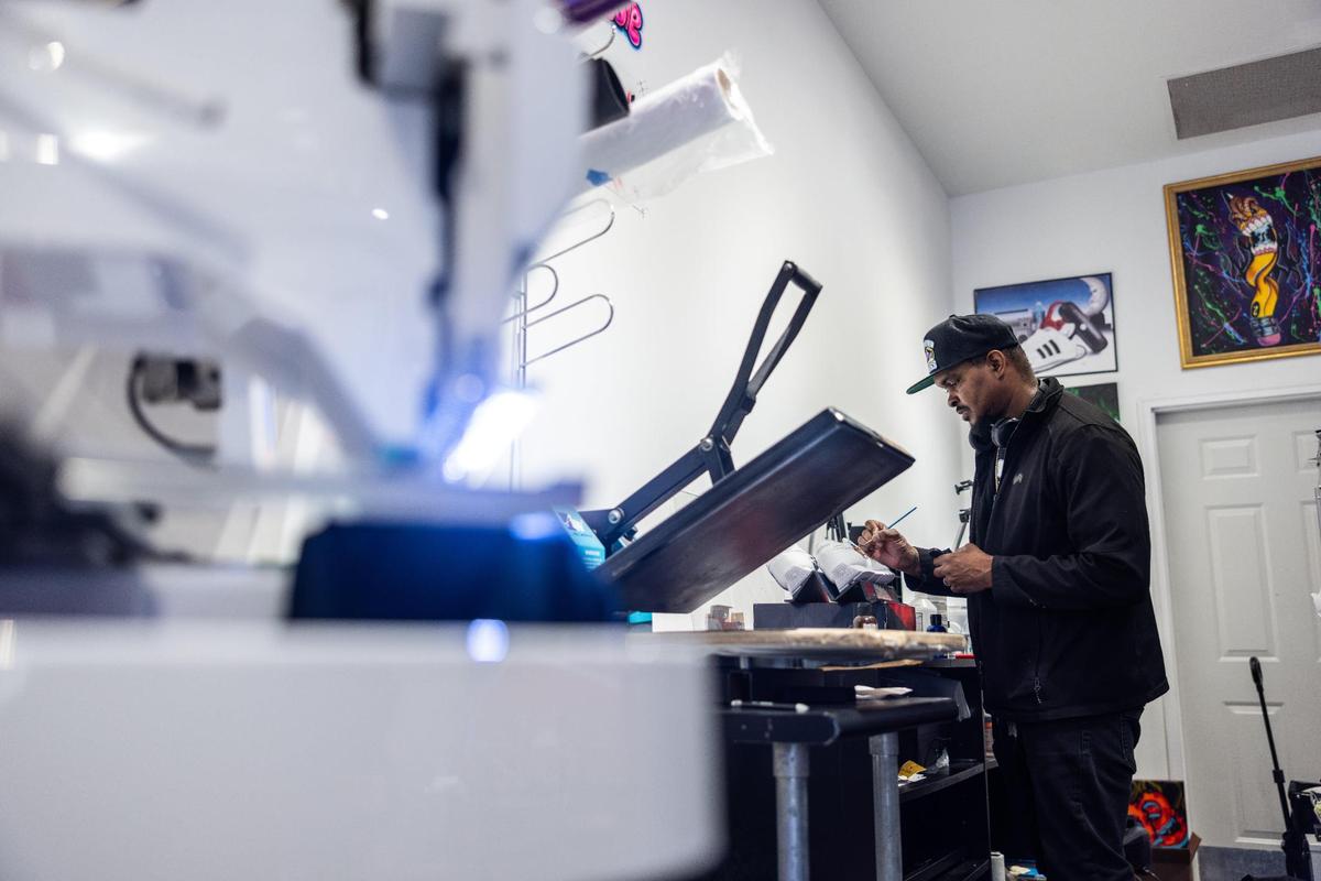 Danyell Butler, co-owner of Modified Kicks, works on painting a pair of sneakers at the Northlake Mall store in this file photo. He said tariffs have been affecting his business.