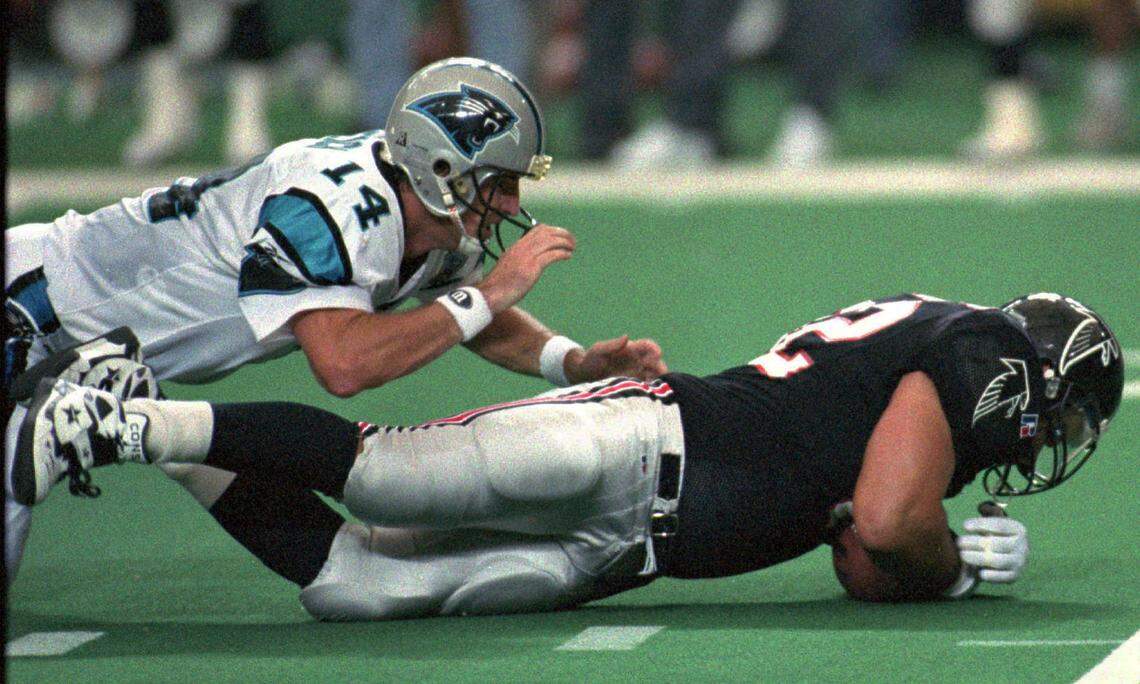 Carolina quarterback Frank Reich (14) dives onto Atlanta’s Lester Archambeau (92) after losing a fumble to Archambeau, who caused the turnover with a strip sack that led to the game-winning field goal in overtime for Atlanta. Reich, who would 28 years later become Carolina’s head coach, was sacked nine times in the game.