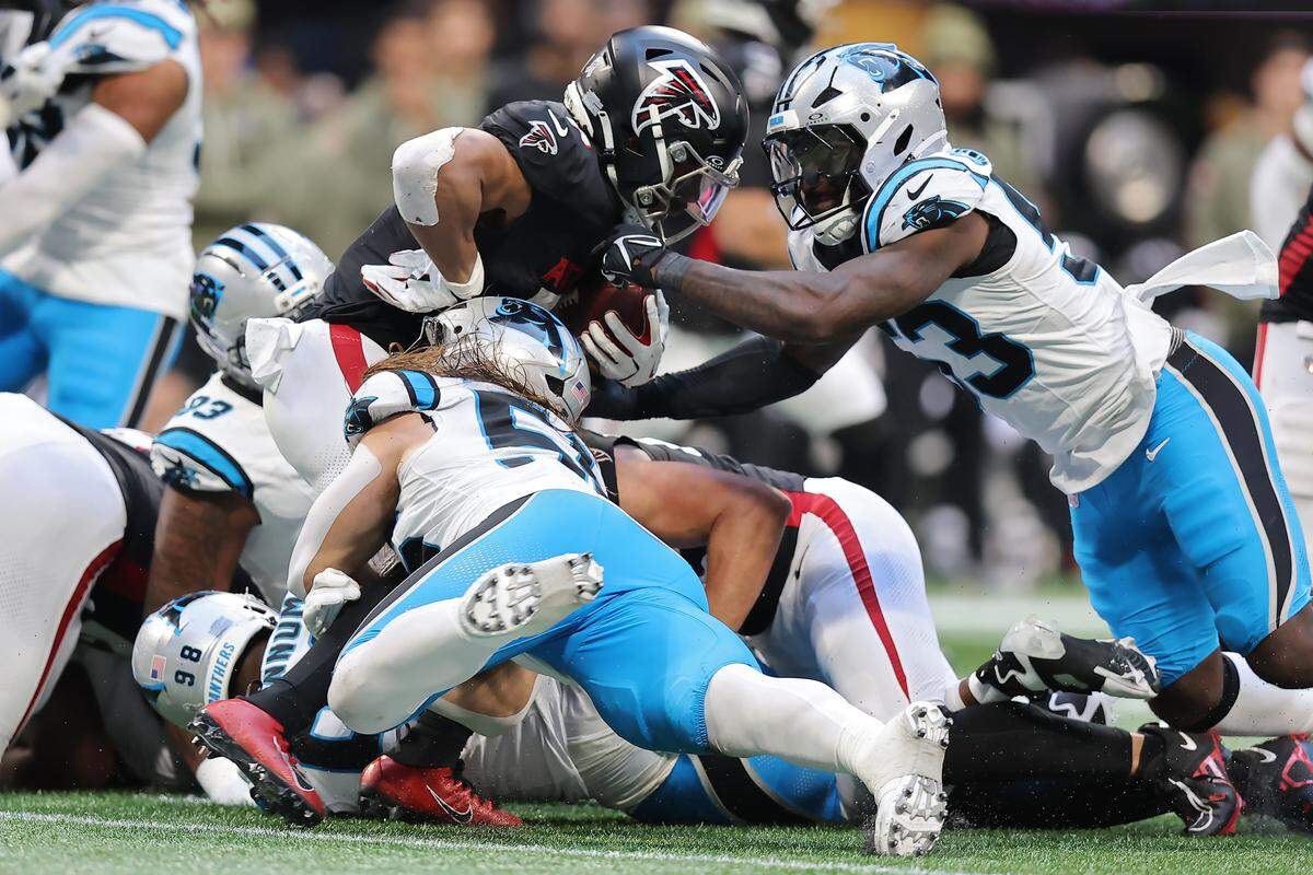 Atlanta Falcons running back Bijan Robinson (7) is tackled by Carolina Panthers linebacker Claudin Cherelus (53) during the fourth quarter at Mercedes-Benz Stadium on November 16, 2025 in Atlanta, Georgia. 