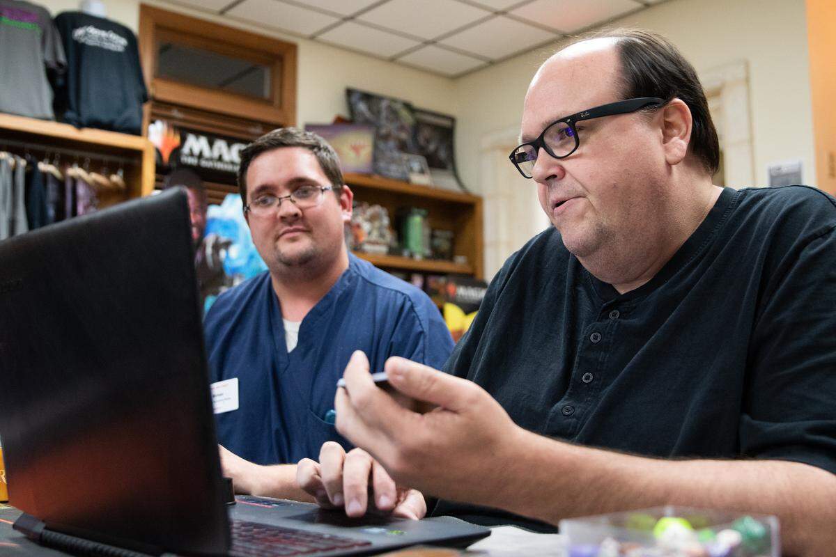 Leon Fortner, 52, (right) is the owner of Get Some Game in Charlotte, North Carolina, the store that purchased cards from Kess Hendrix. Here, he discusses a potential purchase with Michael Spencer, 30.