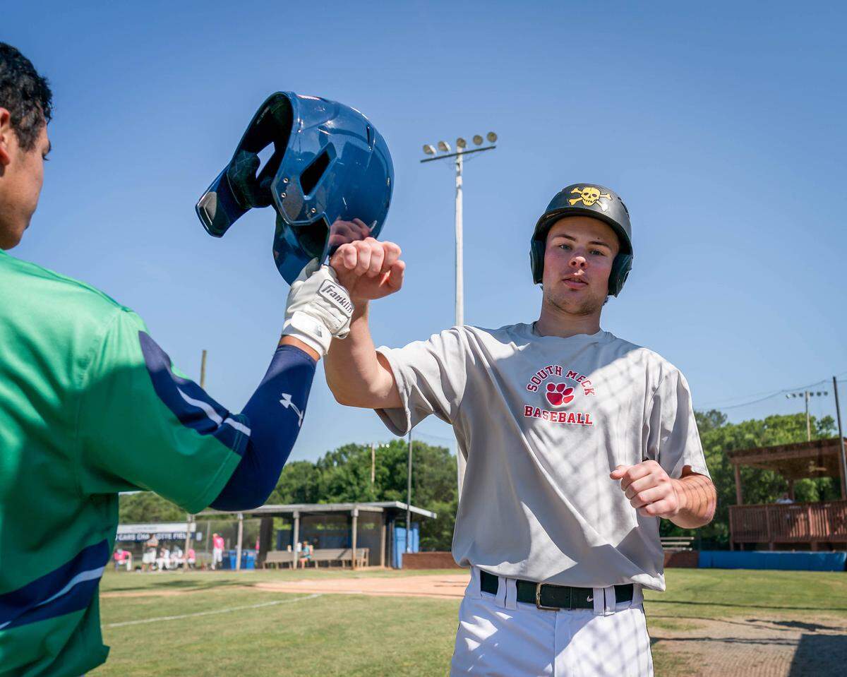 Eli Shenise (right) drives in a run at the Senior Baseball Showecase.