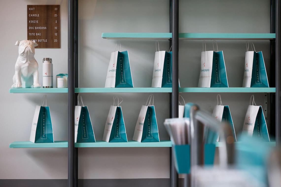 Merchandise and to-go bags sit on shelves made from diving boards at Summerbird at the RailYard in South End.