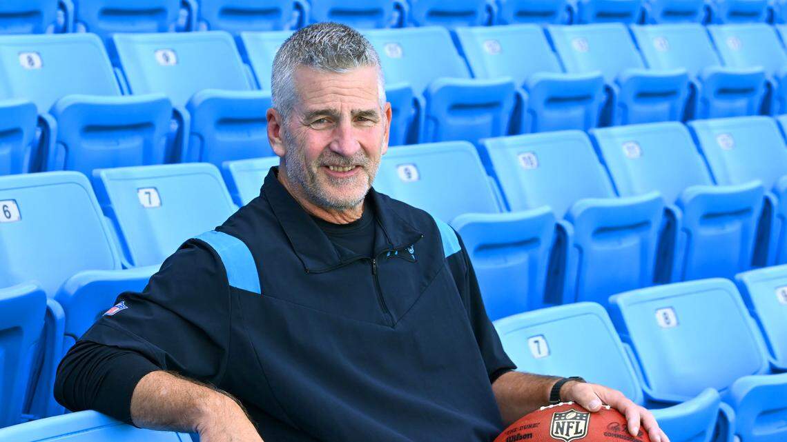 New Carolina Panthers head coach Frank Reich, sitting in the stands at Bank of America Stadium in August 2023, makes his debut for the team in a road game against Atlanta Sept. 10th. In another game at Atlanta, in 1995, Reich led the Panthers in their first-ever game -- but that time as the team’s quarterback.