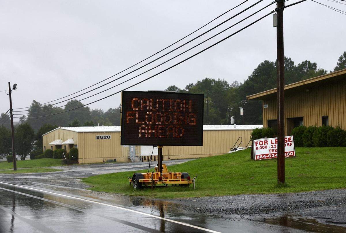 A caution sign warns motorists along Wilkinson Boulevard in Charlotte on Thursday, August 8, 2024, as heavy rains from Tropical Storm Debby passed through the area.