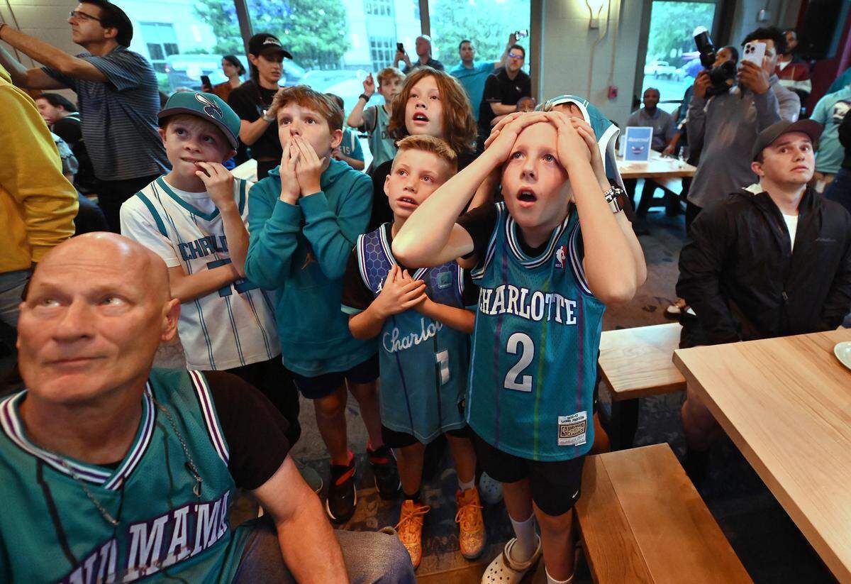 (L-R) Young Charlotte Hornets fans Nixon Stack, Brady Patterson, Greyson Gerhart, Graham Gerhart and Brewer Stack show a range of emotions as the Charlotte Hornets are given the fourth pick in the 2025 NBA Draft Lottery on Monday, May 12, 2025 at Legion Brewing in South Park. Hidden in the back is friend Colin Dyer.