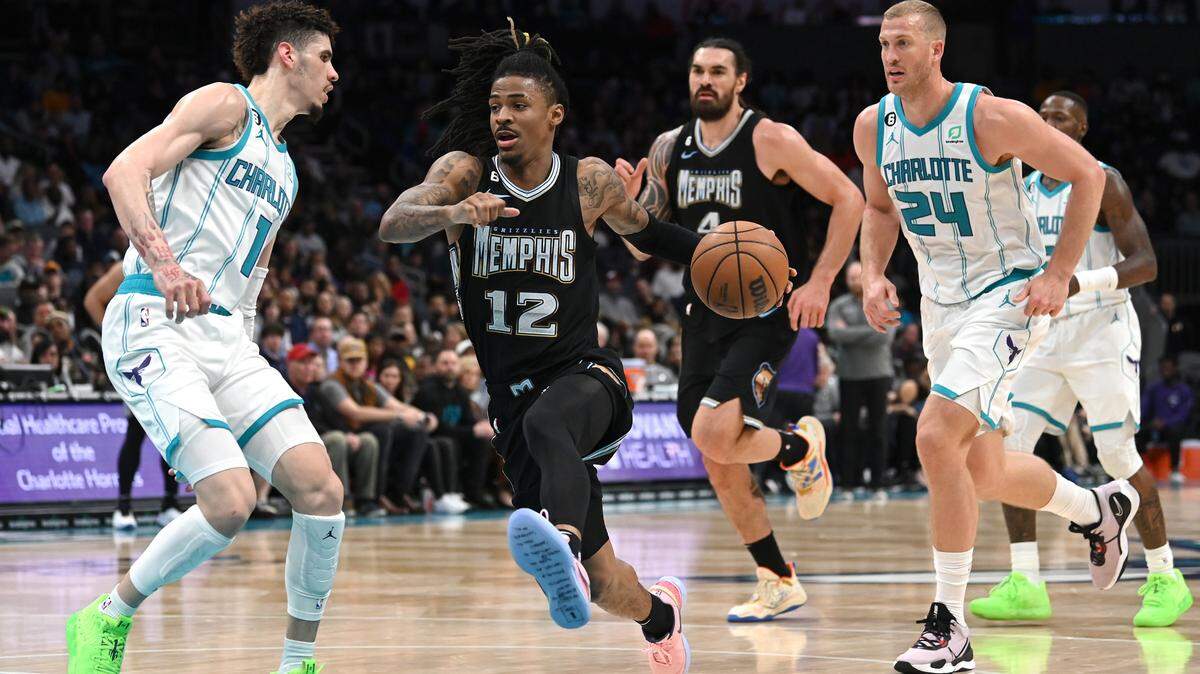 Memphis Grizzlies guard Ja Morant, center, drives to the basket as Charlotte Hornets guard LaMelo Ball, left, applies defensive pressure during a first half action on Wednesday, January 4, 2023 at Spectrum Center in Charlotte, NC.