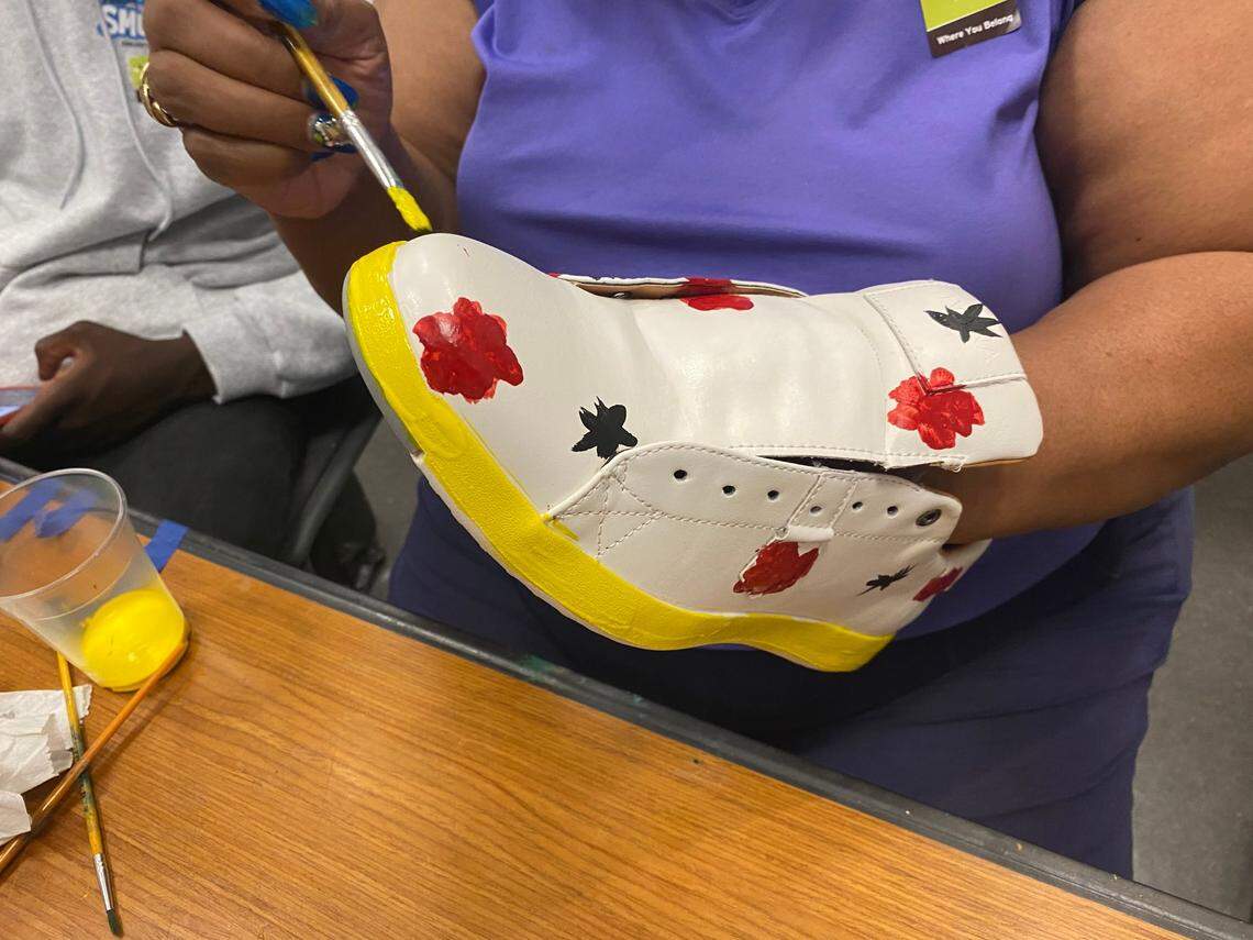 This woman decided to paint the uppers of her shoes with roses and leaves, while painting the midsole yellow.