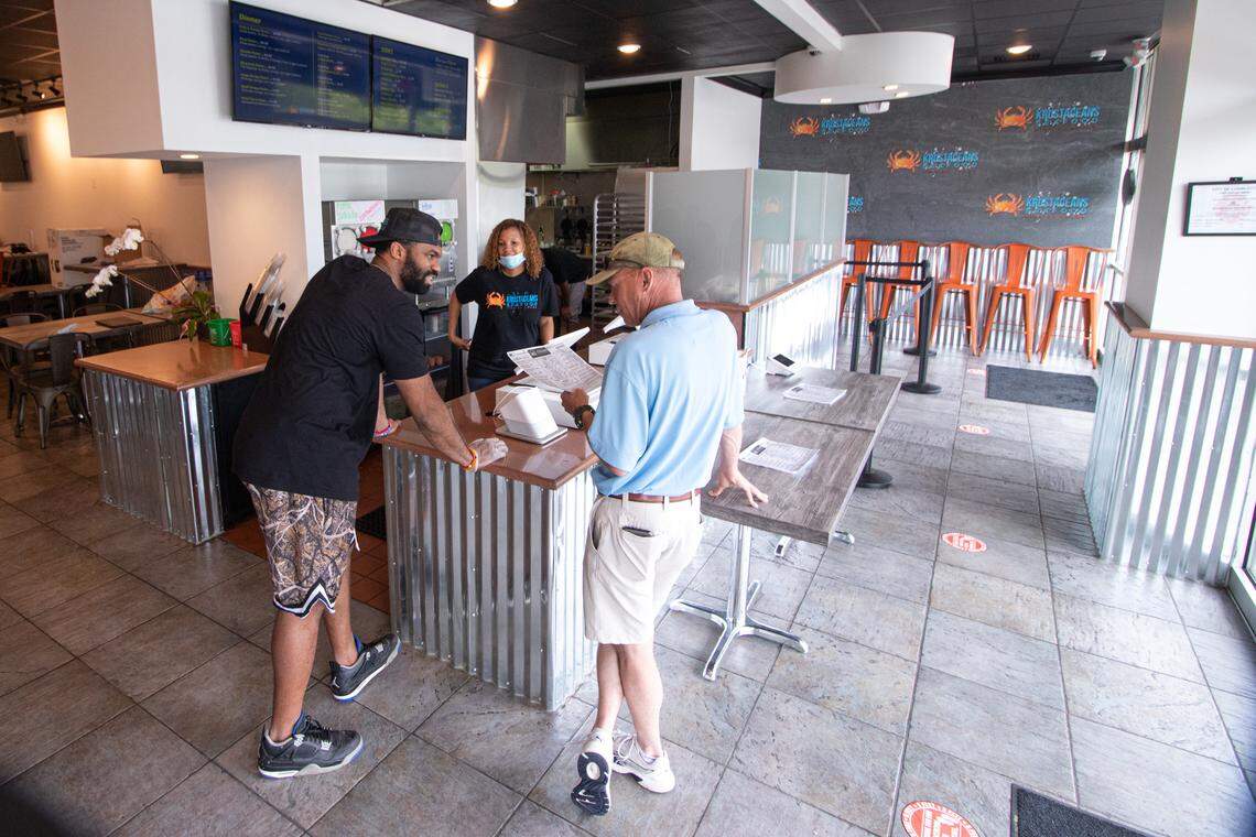 Marcus Lucas and Monica McKelvin describe the menu to a new customer at Krusteaceans restaurant in Charlotte.