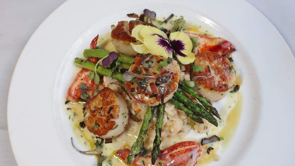 Bentley’s Diver Scallops are served with Lobster Risotto, Black Truffe, Grilled Asparagus and Lobster Sauce.