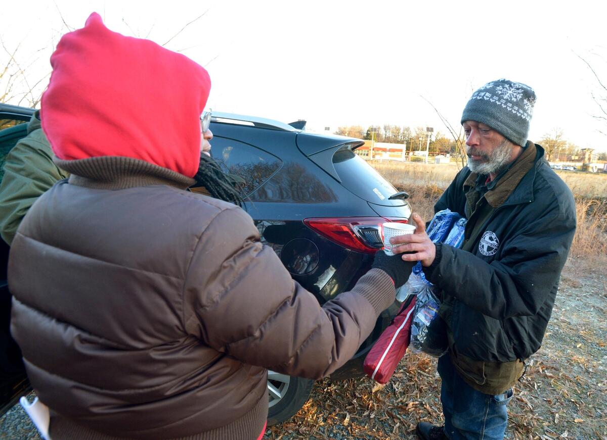 Michael Gault gets a cup of coffee from Mecklenburg County case coordinator Shamika Murray. Volunteers in small groups will headed out on the streets before dawn Thursday to count the number of homeless people in Mecklenburg County.