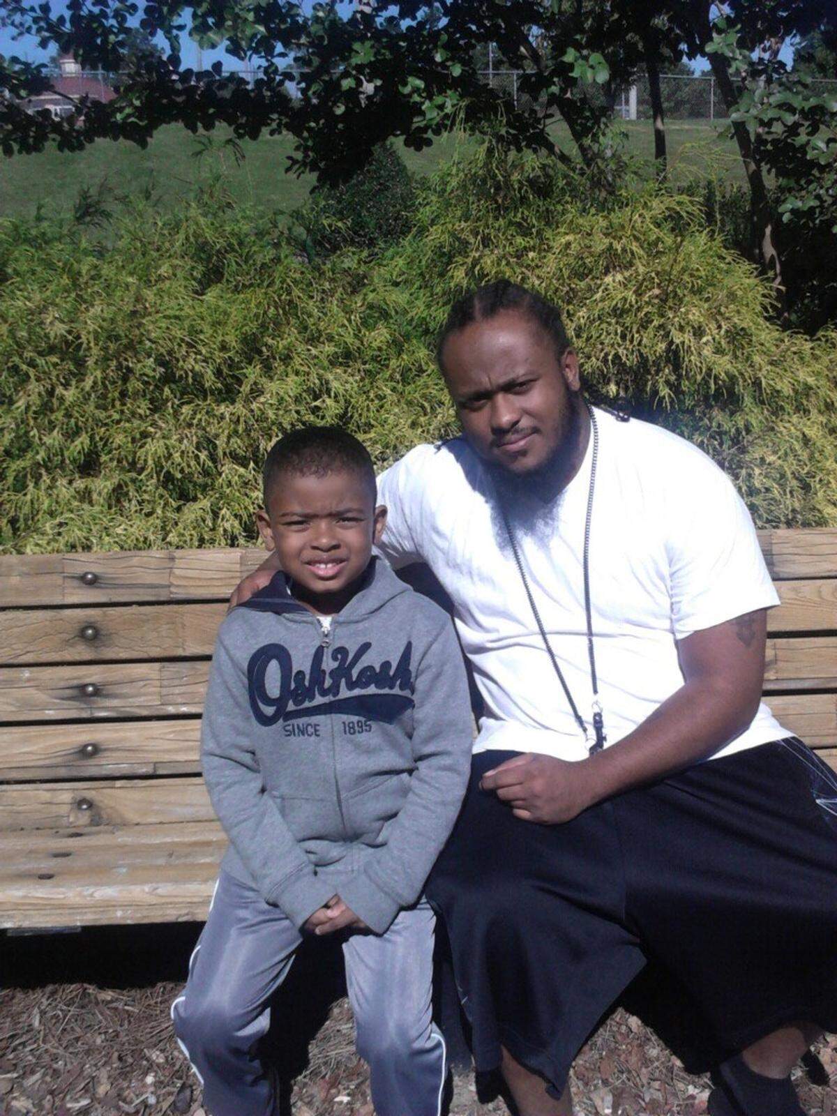 A photo of John Moore on a bench with his son, also named John.