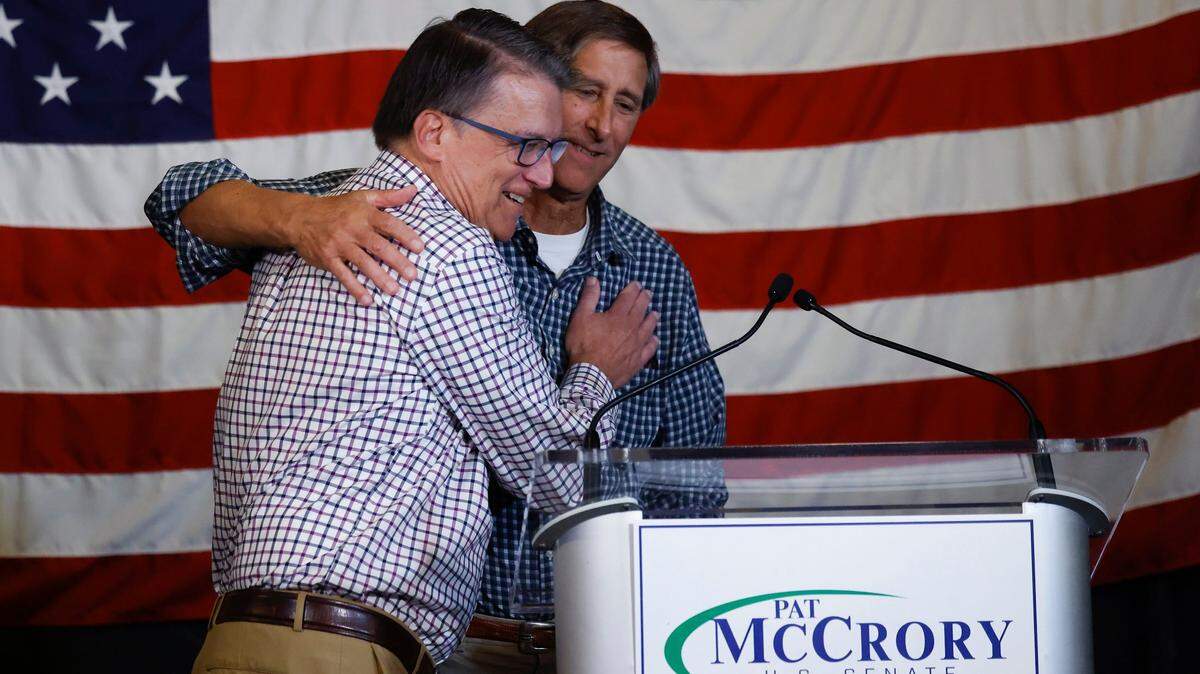 Pat McCrory, left, hugs his brother Phil before speaking to a crowd at Selwyn Pub in Charlotte, NC, after the former mayor and North Carolina governor lost in the Republican primary for U.S. Senate on Tuesday, May 17, 2022.