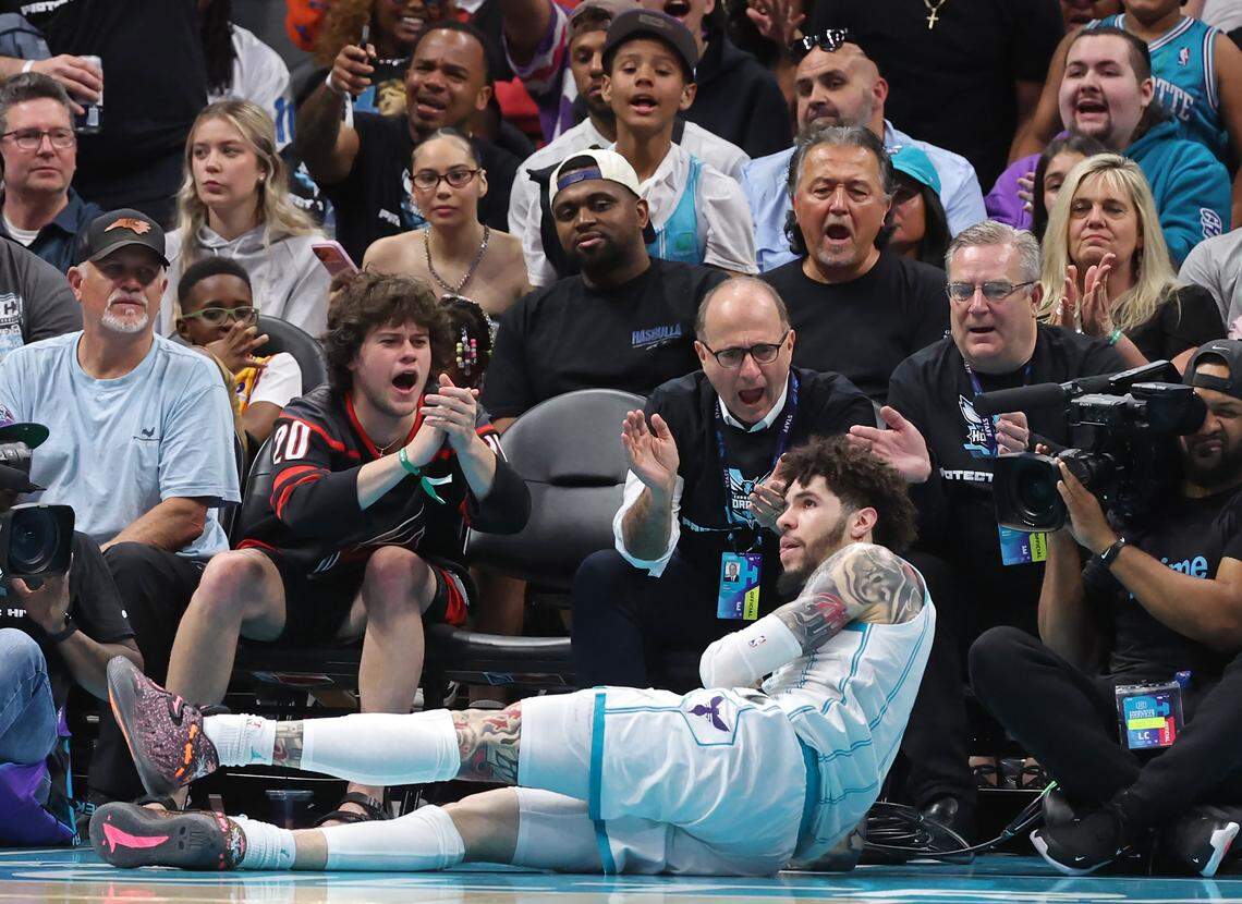 Charlotte Hornets fans offer support to guard LaMelo Ball after he fell to the court during Tuesday’s action against the Miami Heat at Spectrum Center in Charlotte. The Hornets defeated the Heat 127-126.