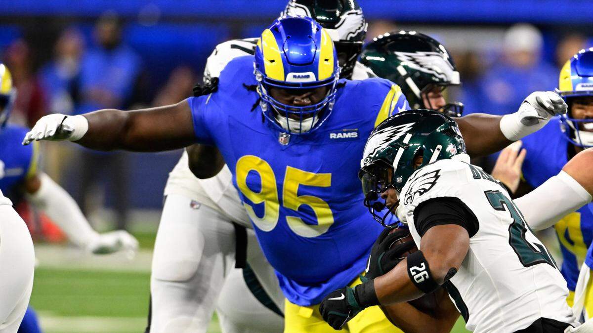 Nov 24, 2024; Inglewood, California, USA; Los Angeles Rams defensive tackle Bobby Brown III (95) tackles Philadelphia Eagles running back Saquon Barkley (26) during the first half at SoFi Stadium. Mandatory Credit: Alex Gallardo-Imagn Images