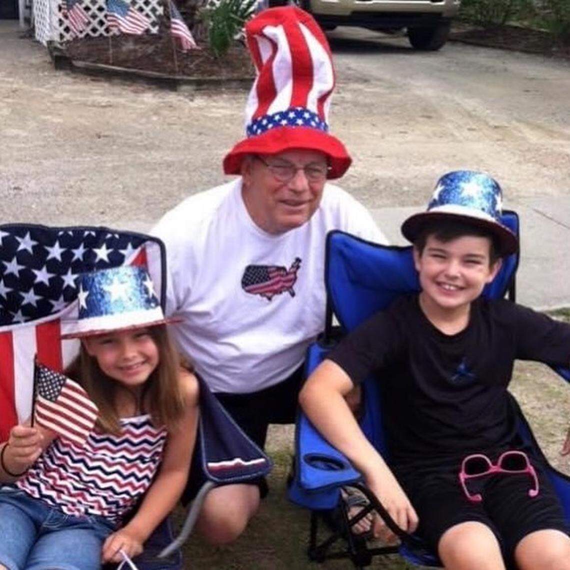 Bill Bauer (center) poses for a photo with two of his grandchildren at a Fourth of July event. Bauer died of COVID-19 on April 16th in a Charlotte hospital. He was 78.